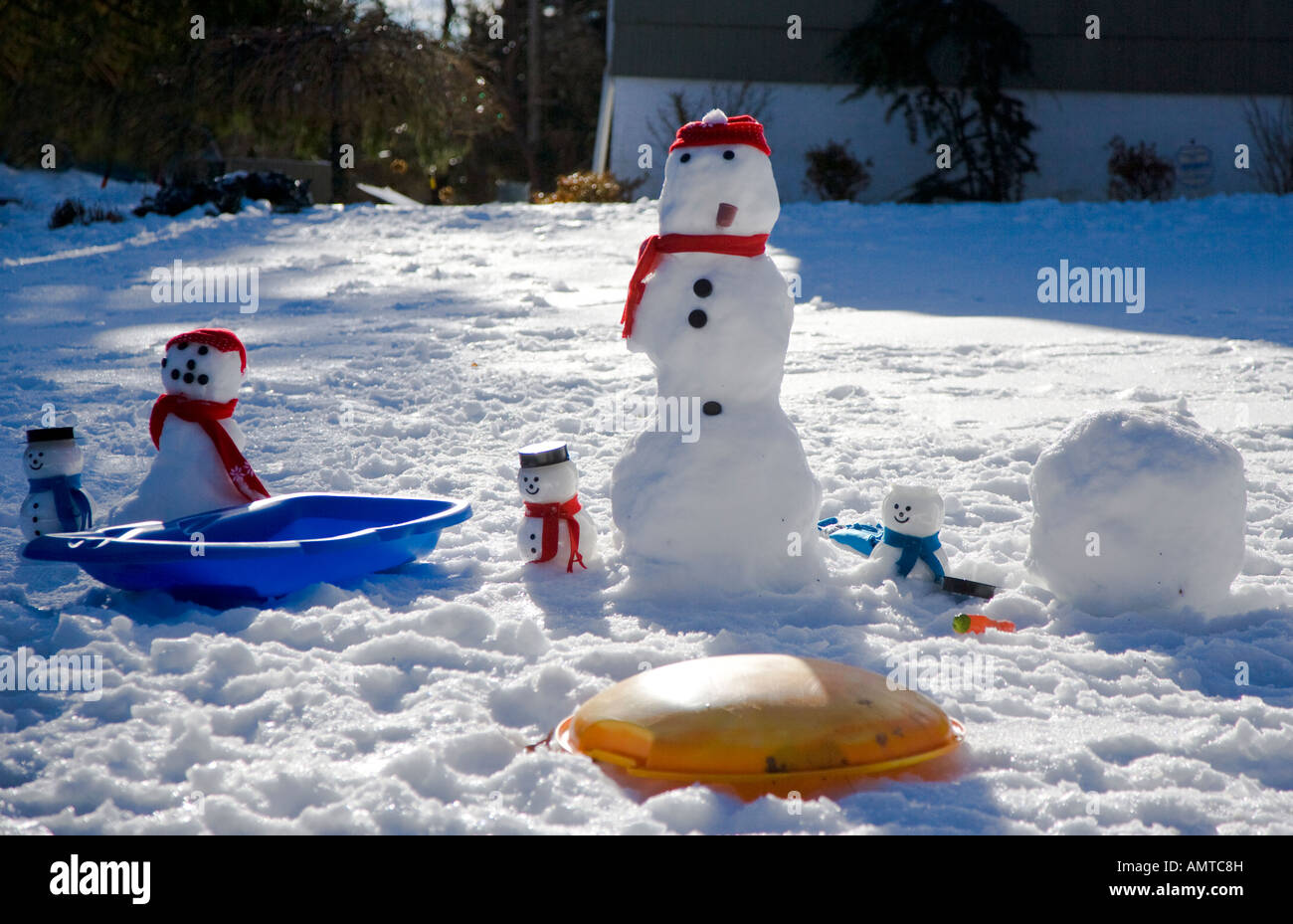 Snowmen on a suburban lawn Stock Photo
