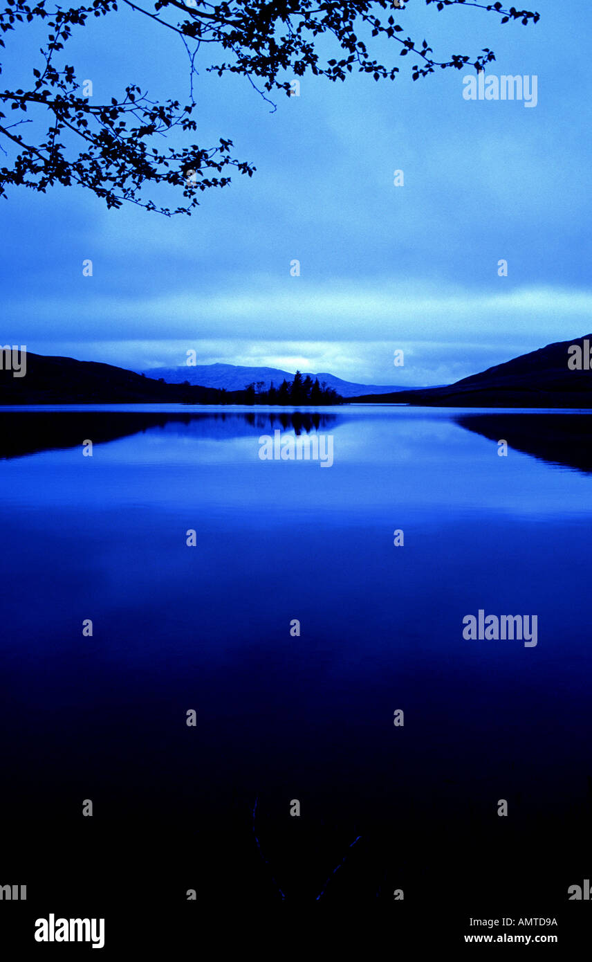 Loch Tarff Scottish Highlands Blue filtered with reflections of trees and mountians Stock Photo