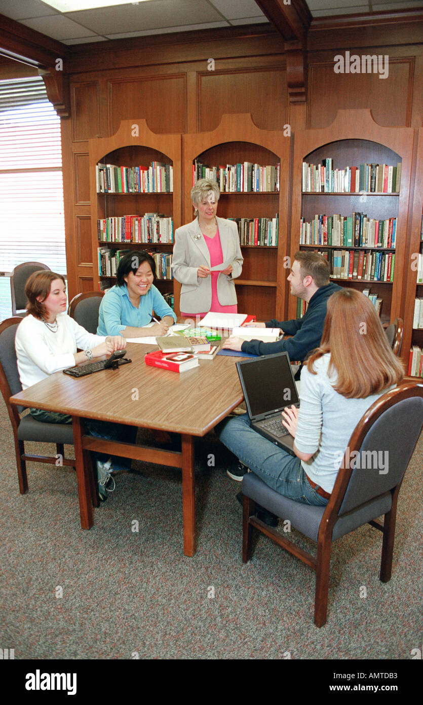 College students work in a group with professor on a research project involving team work Stock Photo