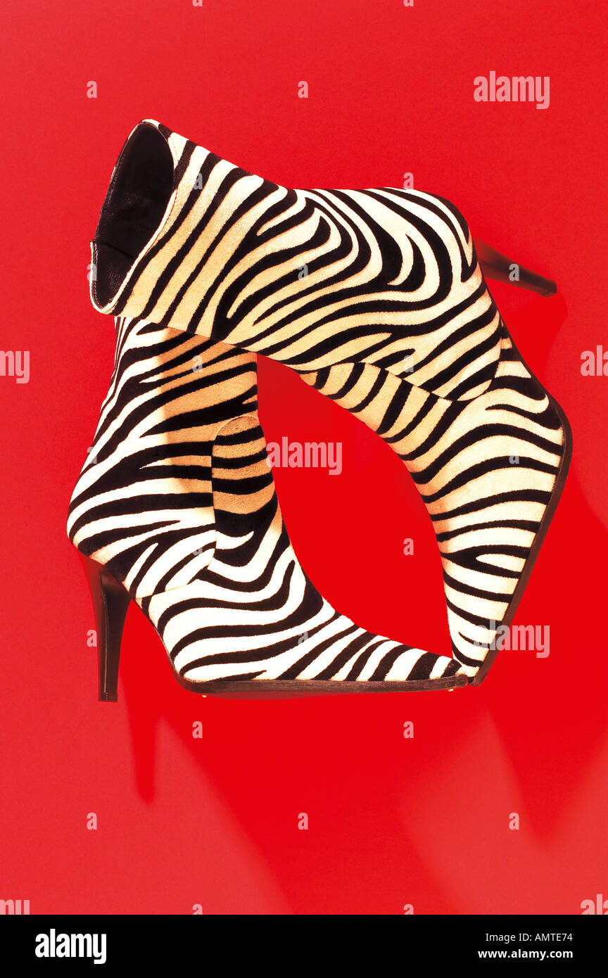 Shot of a pair of ladies zebra pattern ankle boots photographed from above on a bright red background Stock Photo