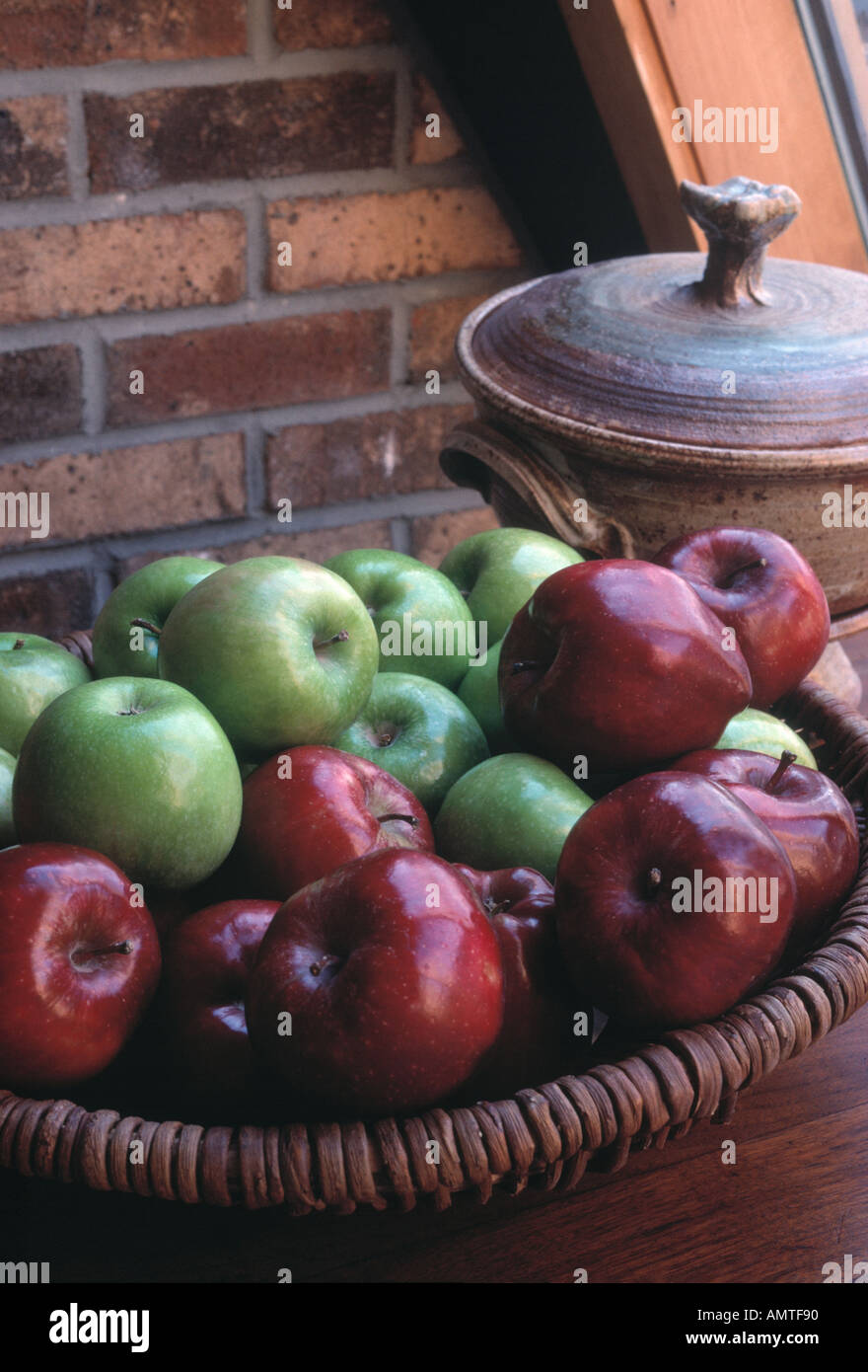 apples in a basket on a buffet near a window with natural light Stock Photo