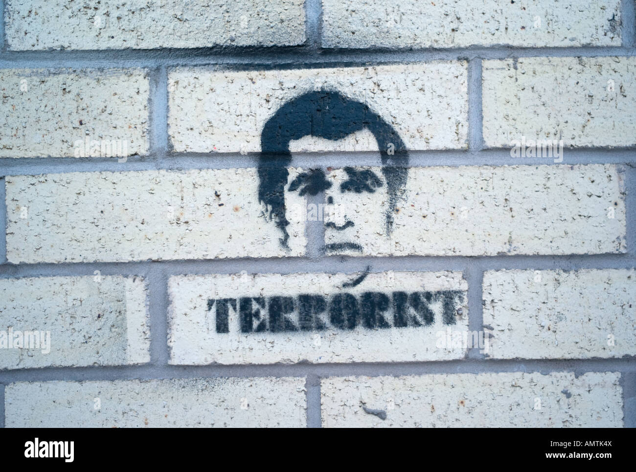 Stencilled graffiti showing the face of President George W Bush as a terrorist on a brick wall Stock Photo
