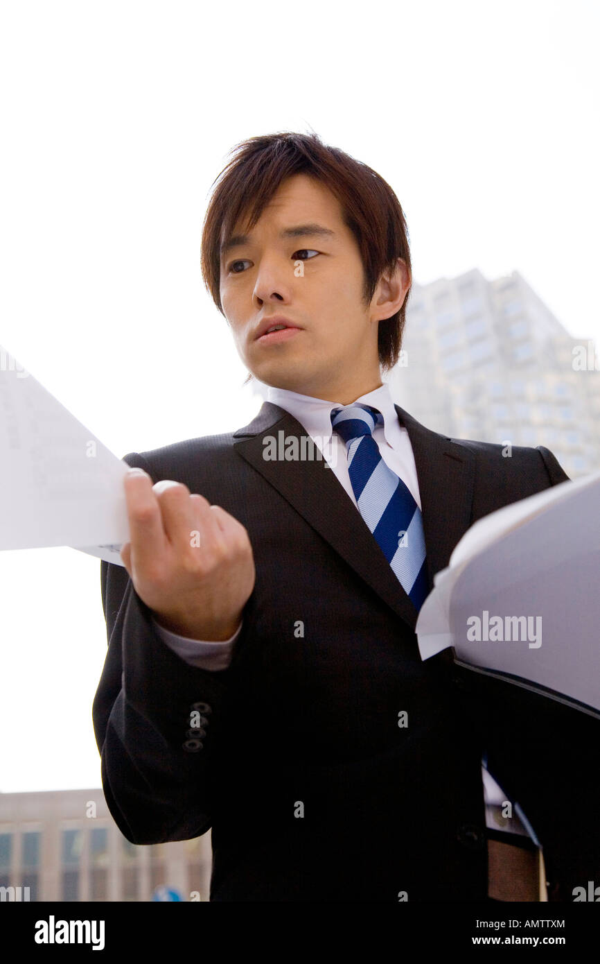 Japanese office worker checking document at street Stock Photo Alamy