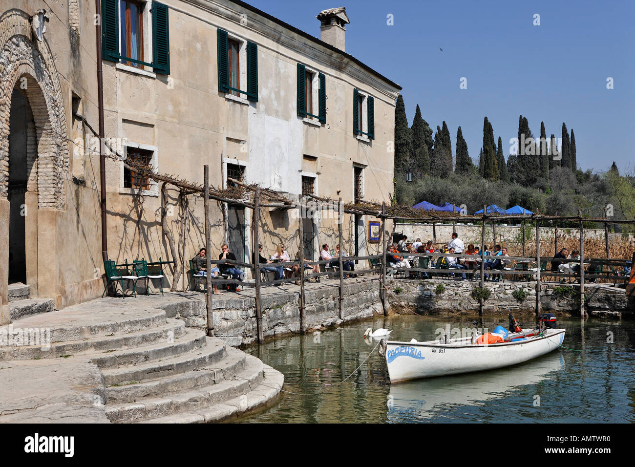 A public cafe at the small harbour of the luxury hotel on the Punta S. Vigilio, Lake Garda, Italy Stock Photo
