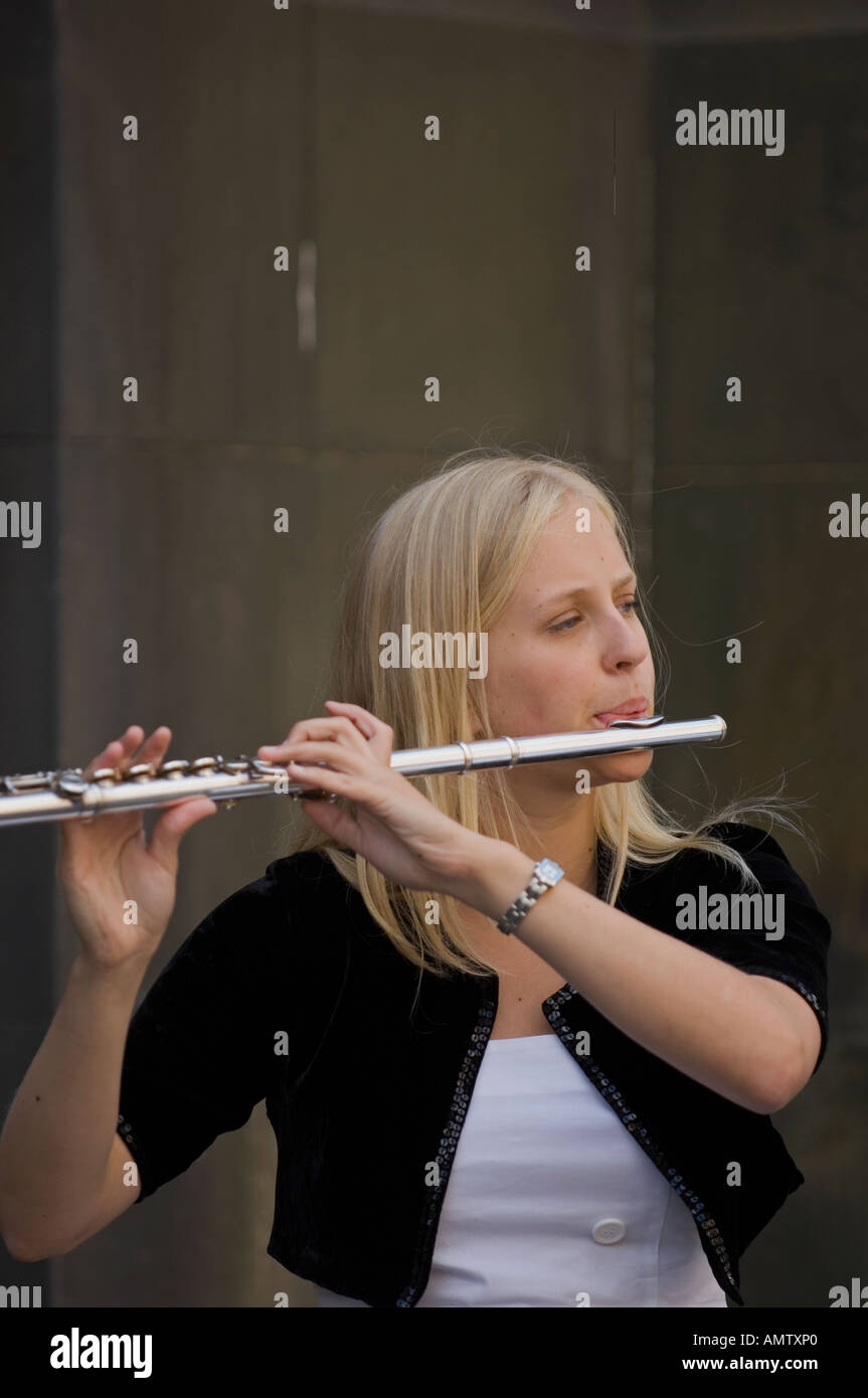 Young woman playing the flute in the street Stock Photo