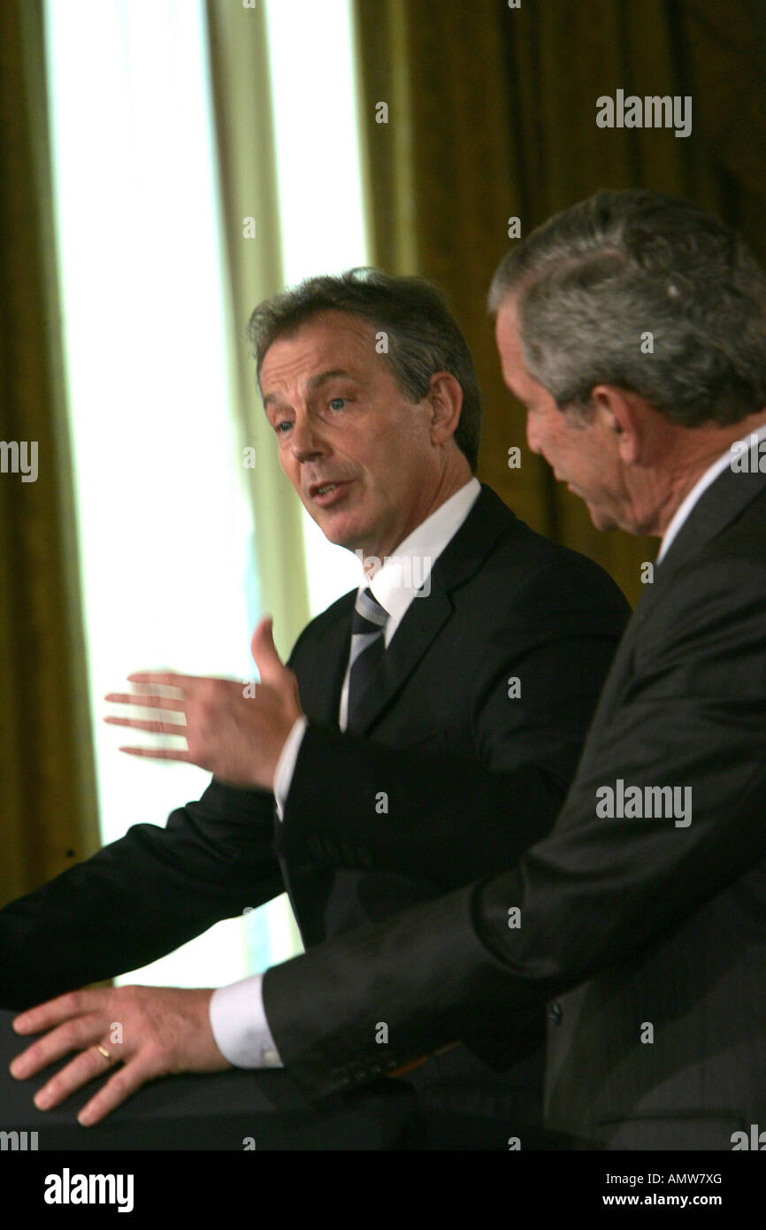 UK Prime Minister Tony Blair watches President George W Bush during a joint news conference in the East Room of the White House Stock Photo