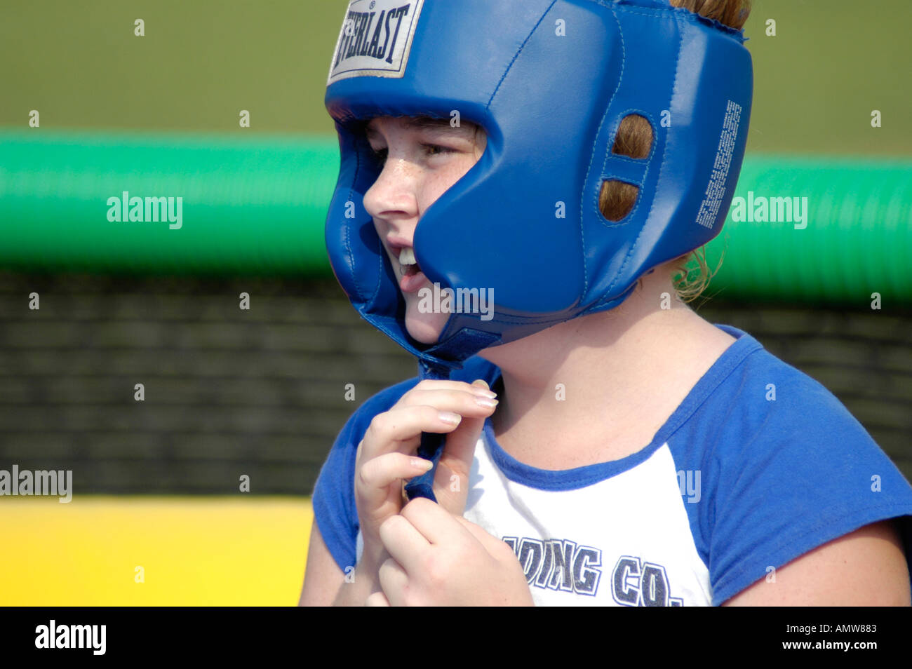 Girl with boxing head gear on for protections from hits and shots to