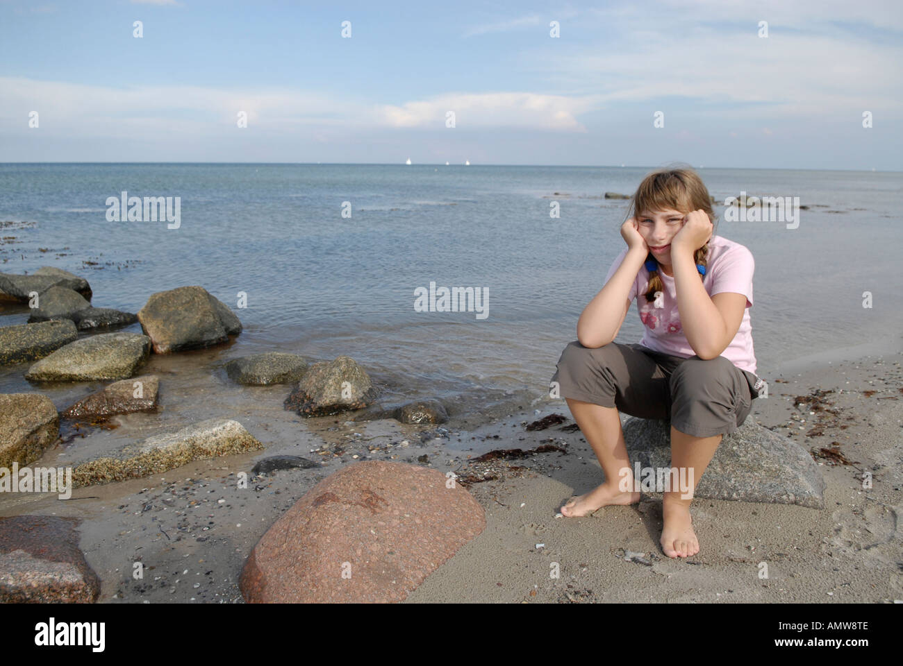 Girl siting at the baltic sea beach from maasholm schleswig Holstein Germany Stock Photo