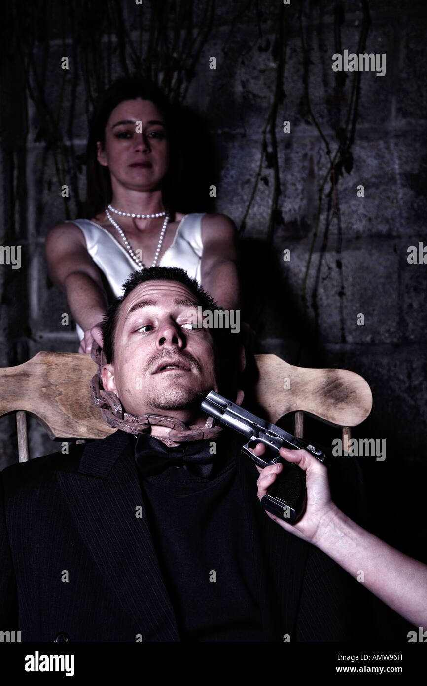 Young man being held at gun point by two females Stock Photo - Alamy