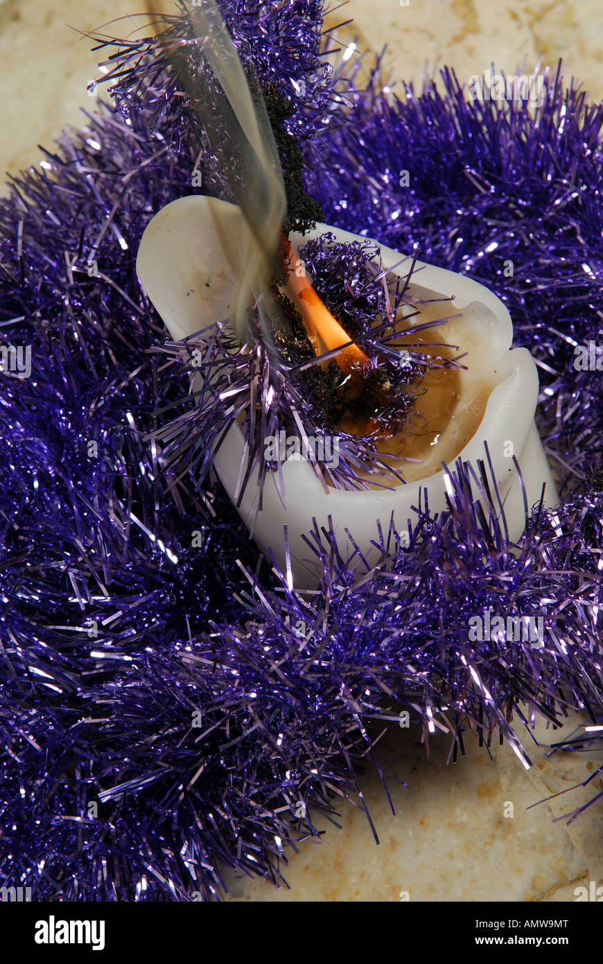 Lit candle catches fire to christmas tinsel Stock Photo Alamy