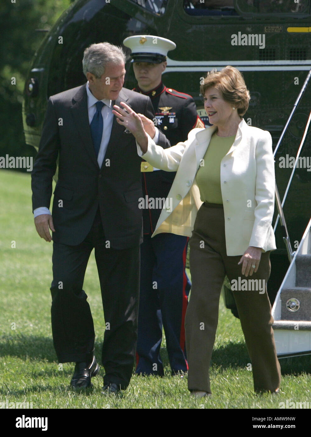 President George W Bush looks at First Lady Laura Bush as she waves to crowd as they arrive at the White House Stock Photo