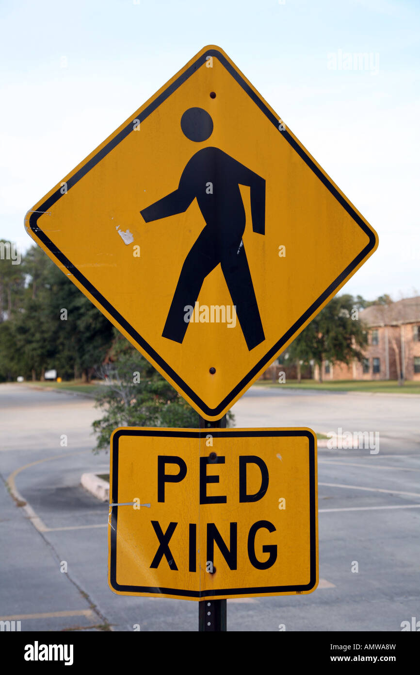 Pedestrian crossing sign yellow bent sign man walking cross a road Stock Photo