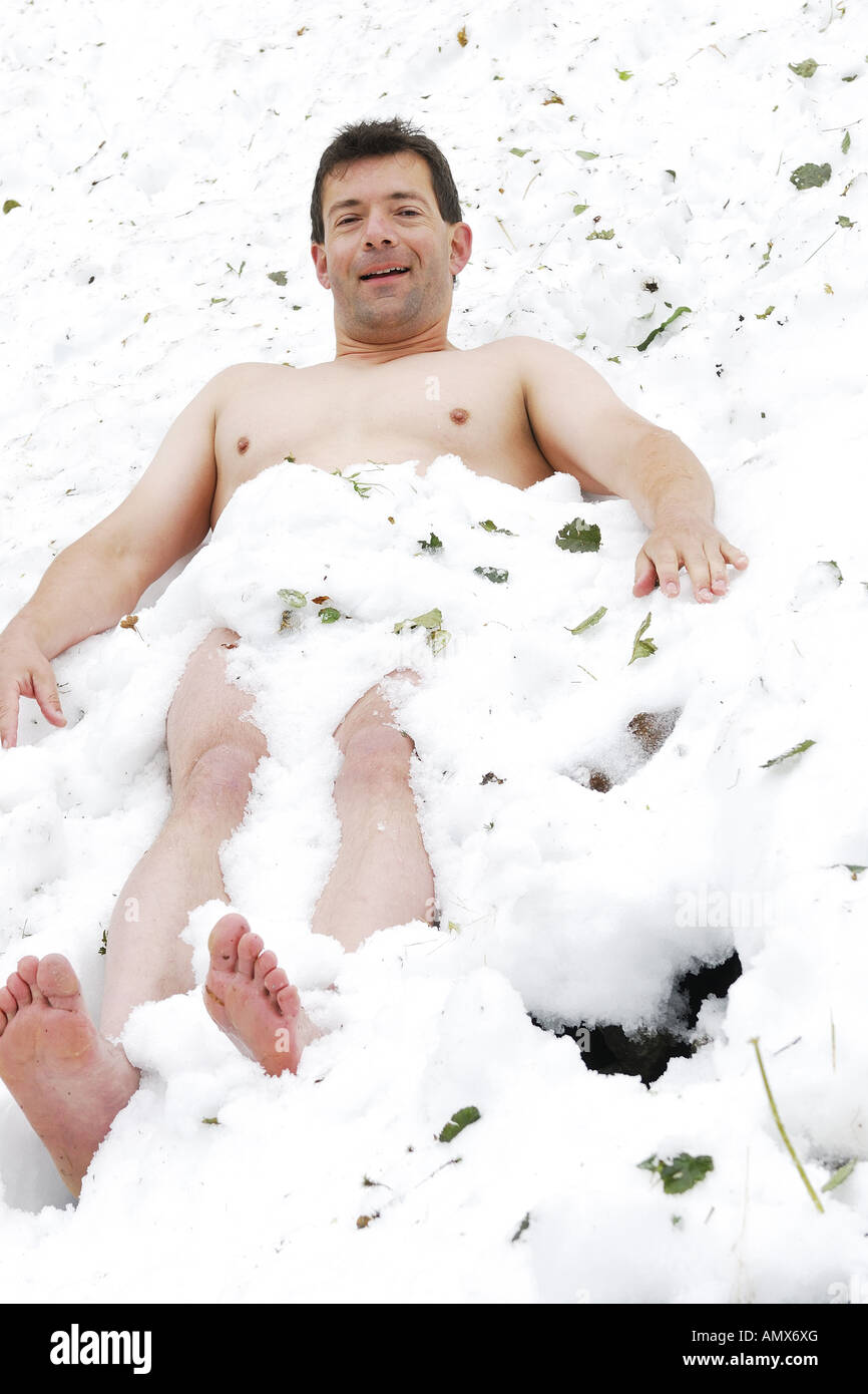 naked man lying in snow, Austria Stock Photo