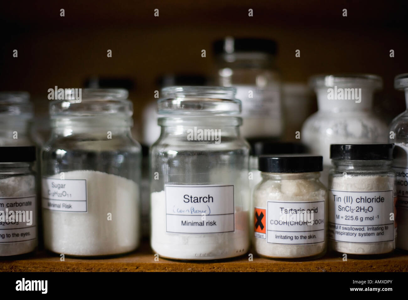 Glass storage jars containing chemicals in a school laboratory Stock