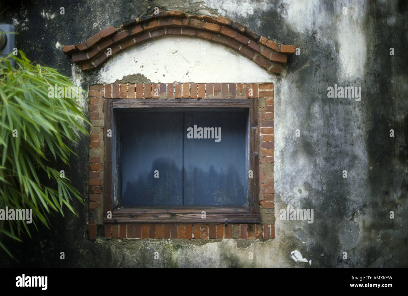 closed old brick window with bamboo,rainy day Stock Photo
