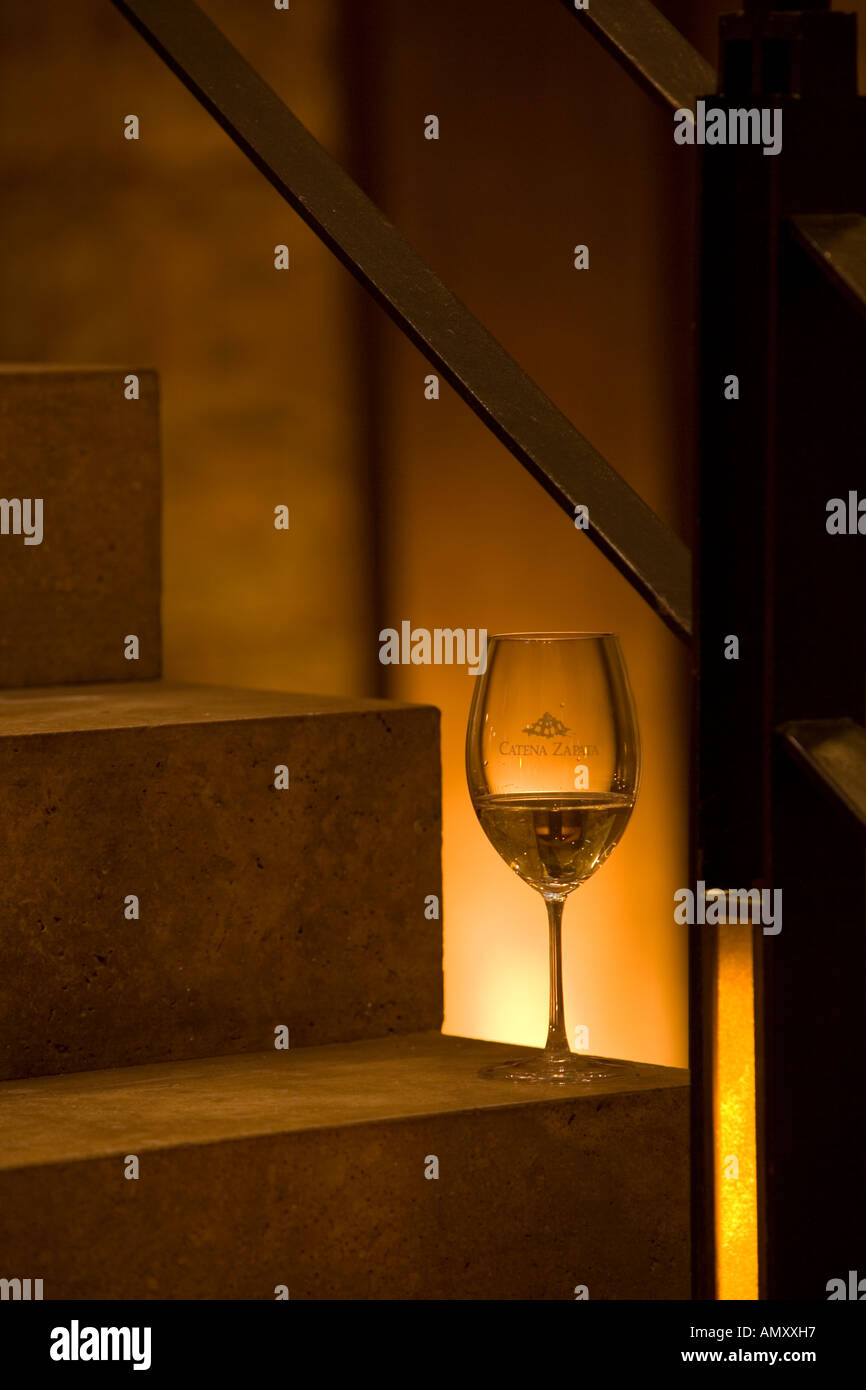 A glass of white wine is silouhetted and back lit sitting on stone steps in the Bodega Catena Zapata in Lujan de Cujo, Mendoza, Argentina. Stock Photo