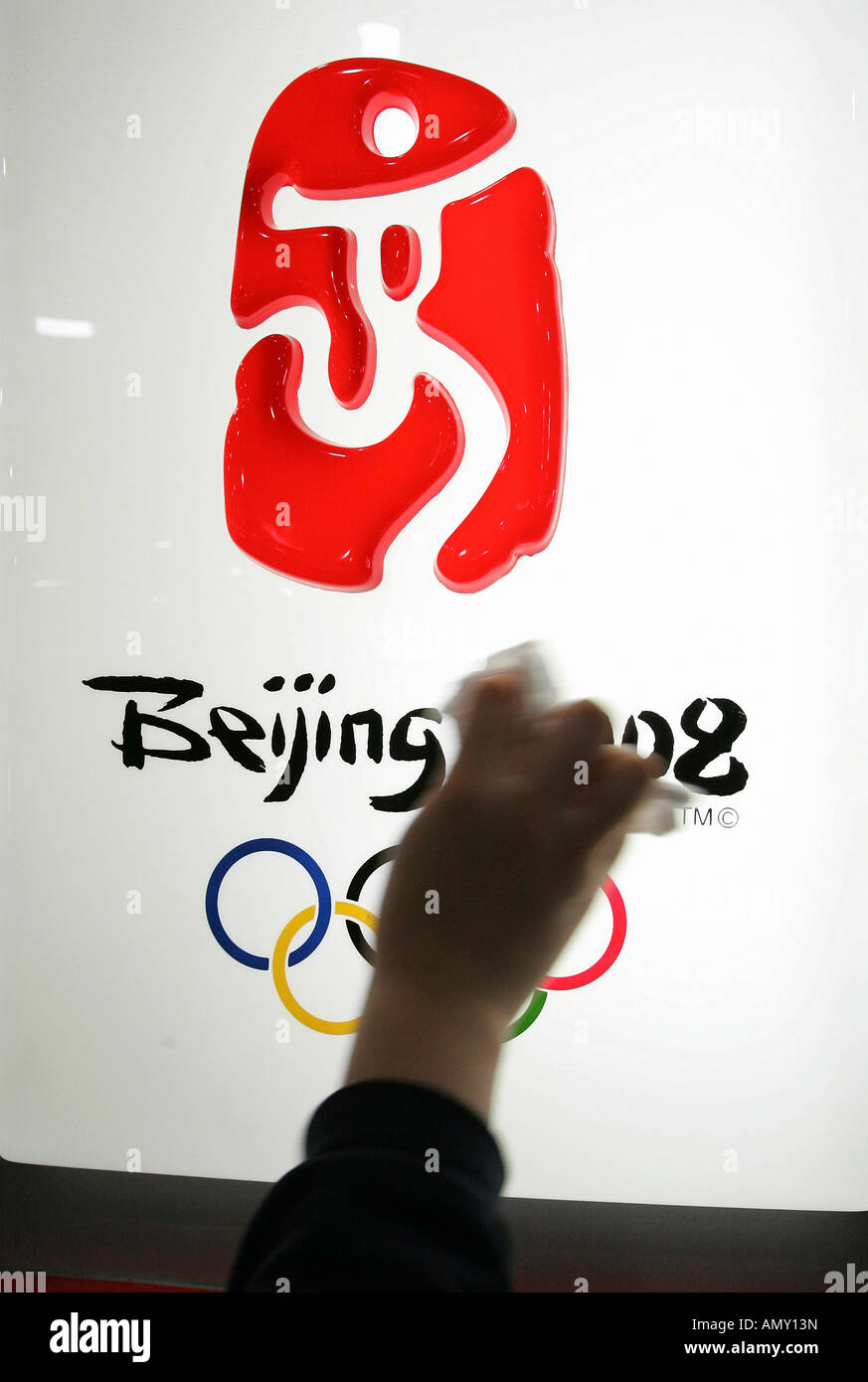 Hand cleaning the logo of Summer Olympic Games 2008 Stock Photo