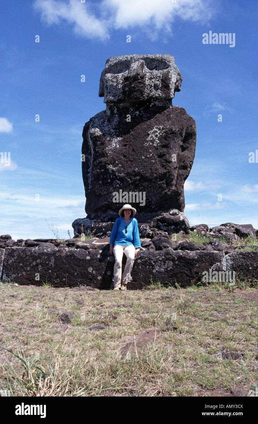 Tourist sitting under restored moai at Anakena Beach Easter Island Chile South Pacific Ocean Stock Photo