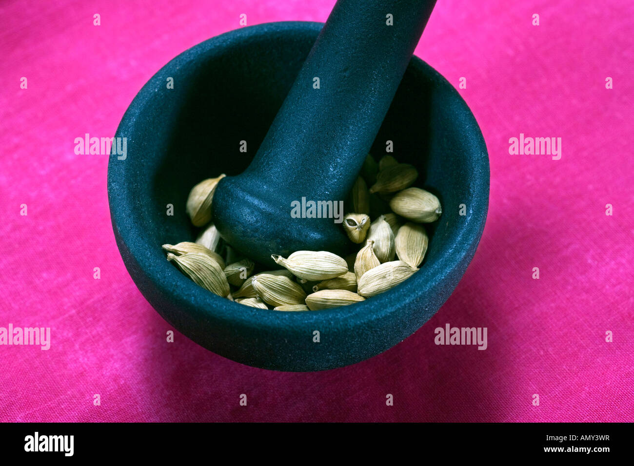 Cardamom pods in pestle Stock Photo
