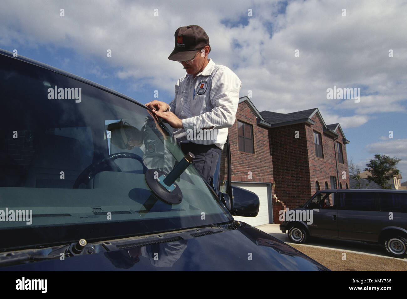 Mobile automotive glass installer uses hands to fit weatherstrip trim