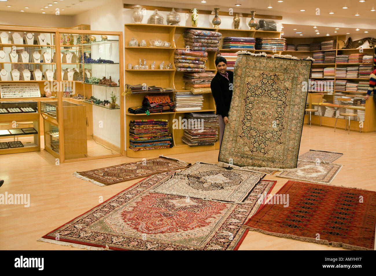 Kashmiri carpet salesman showing a fine carpet in his showroom in New Delhi  in India Stock Photo - Alamy