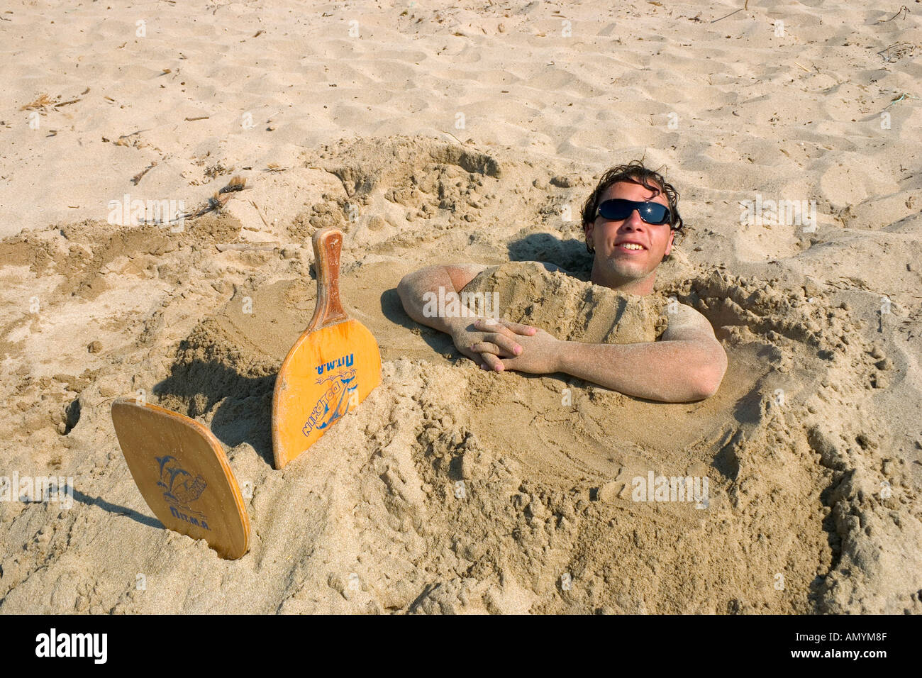 man in sand play on the beach Voidokilia Bay Peloponnese Greece Stock Photo