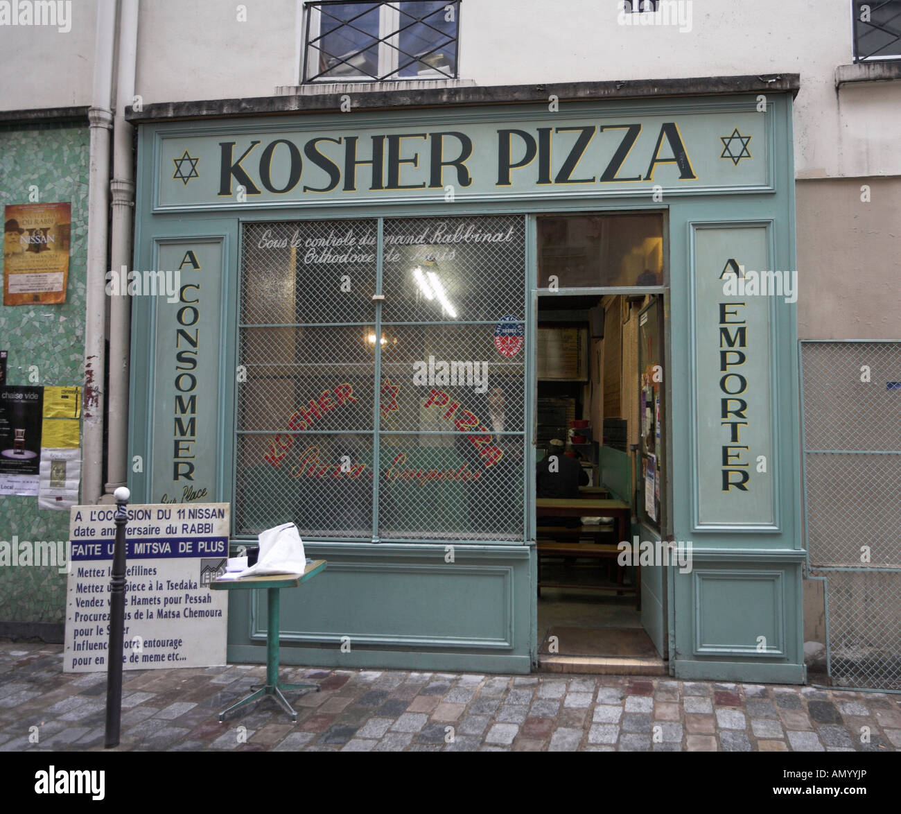 Kosher Pizza in the Marais, the Jewish quarter of Paris France. Wire mesh window grills protect the glass from vandalism Stock Photo