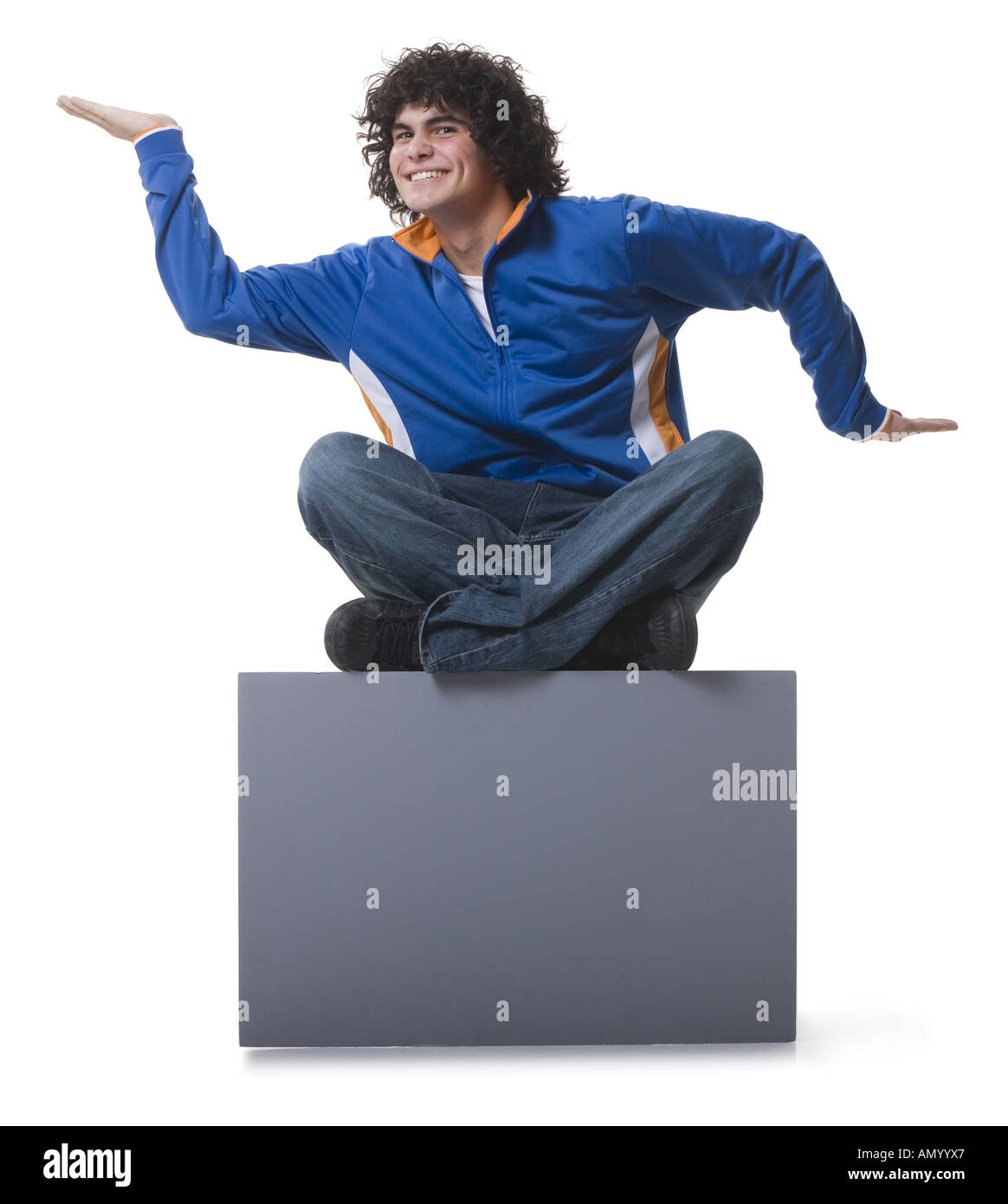 Portrait of a teenage boy sitting on a blank sign Stock Photo - Alamy