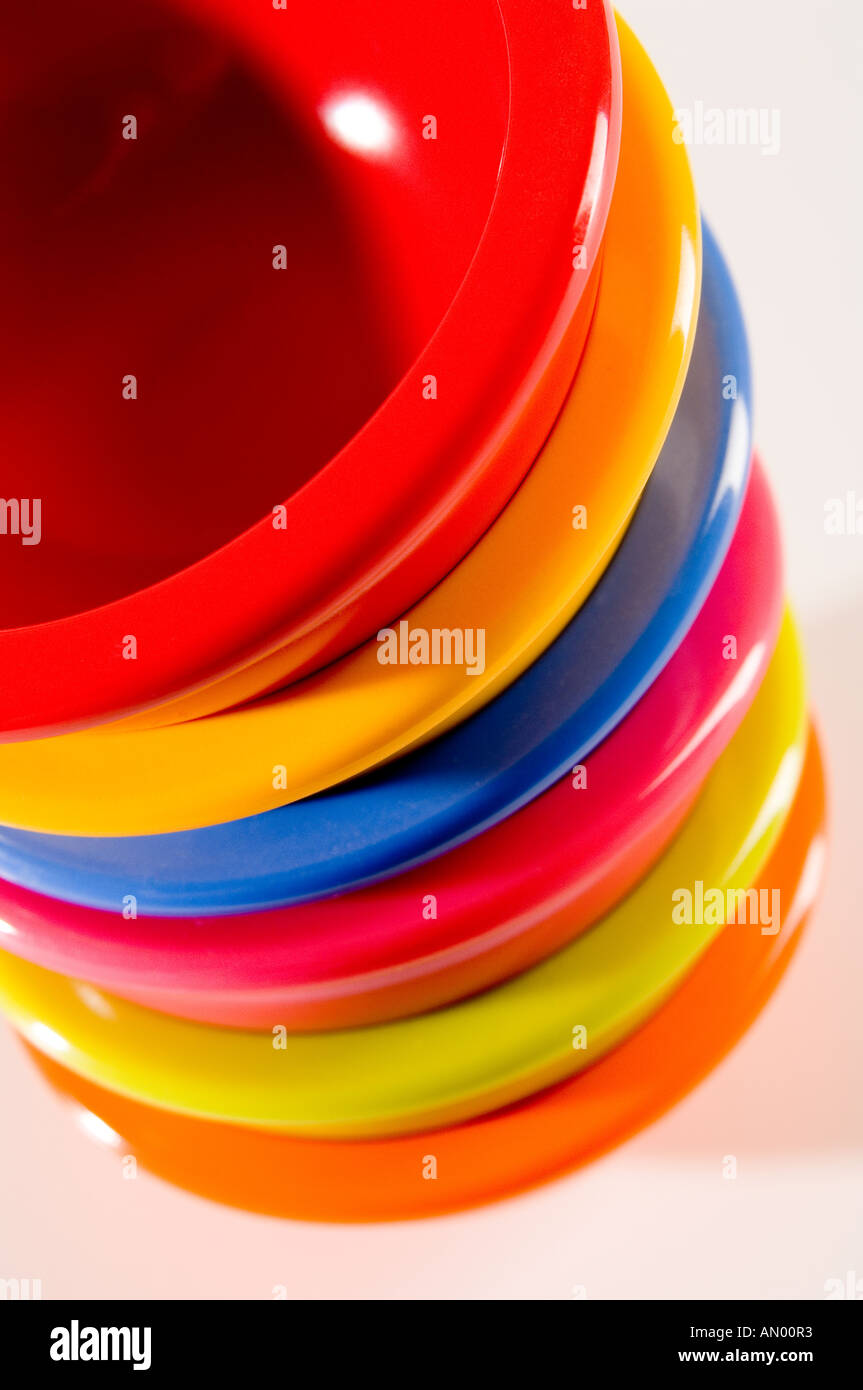 Set of six small multi-coloured bowls, piled up and shot from above on a white background Stock Photo