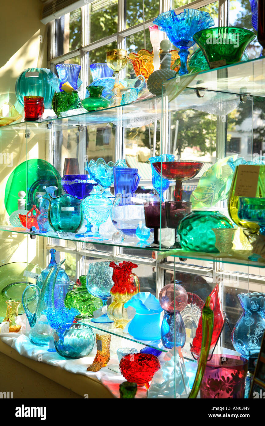 Shelves of colorful glass dishes on display in shop Stock Photo