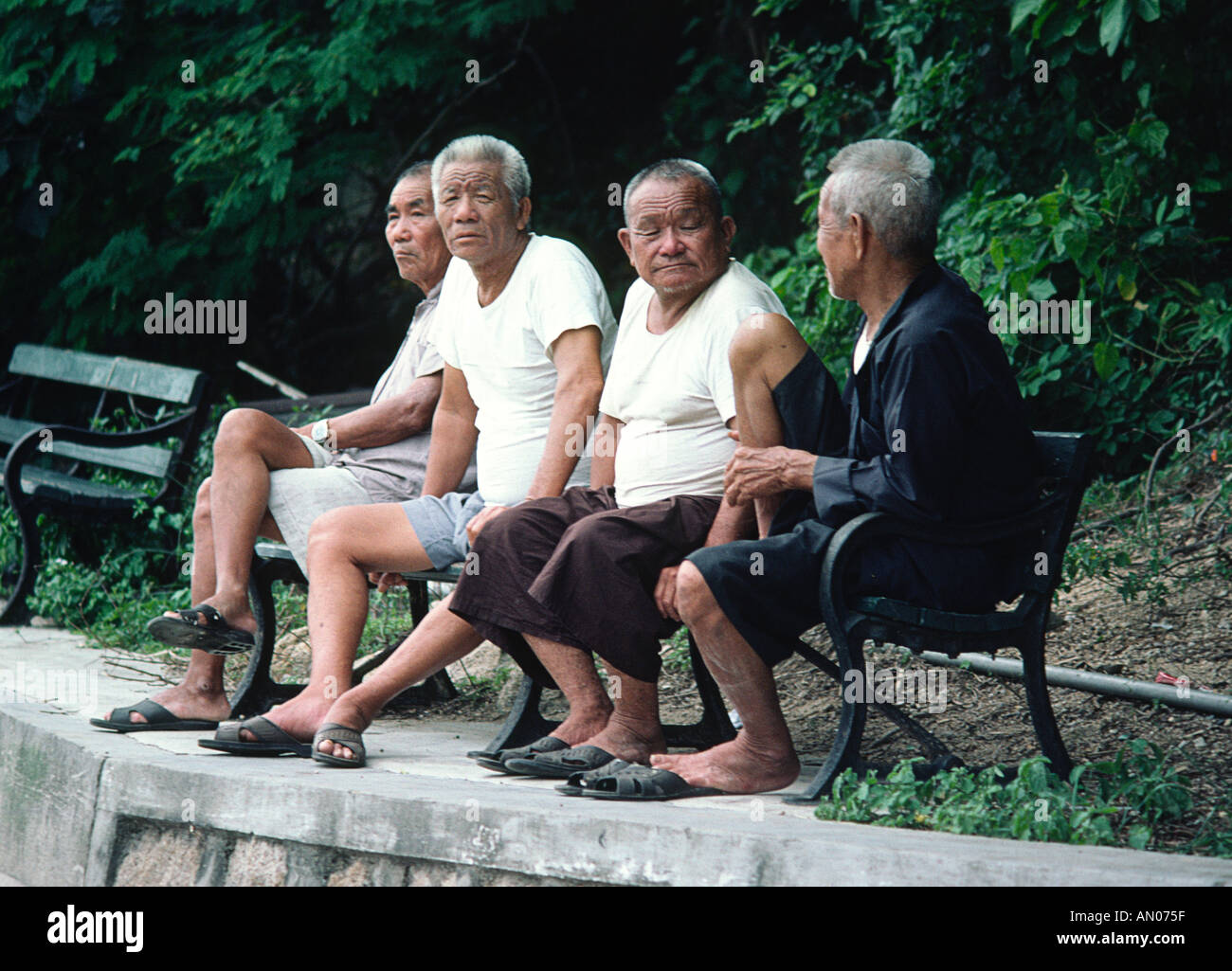 Four friendly old men on a bench Hong Kong Stock Photo Alamy