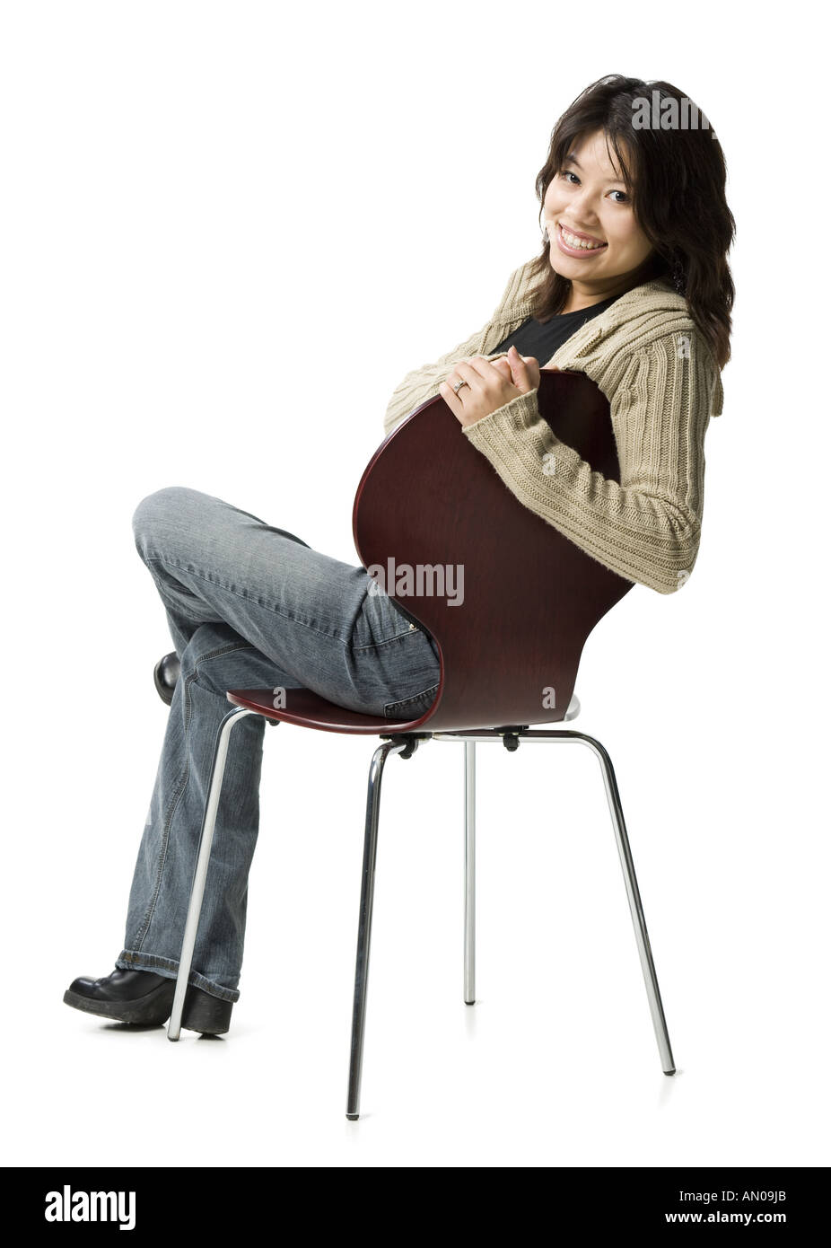 Portrait of a woman sitting on a chair and smiling Stock Photo - Alamy