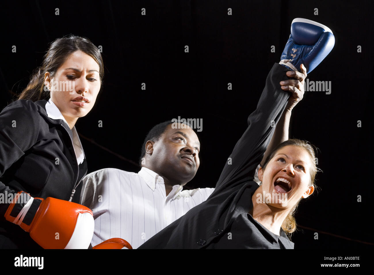 Low angle view of a referee declaring the winner of a boxing match Stock Photo