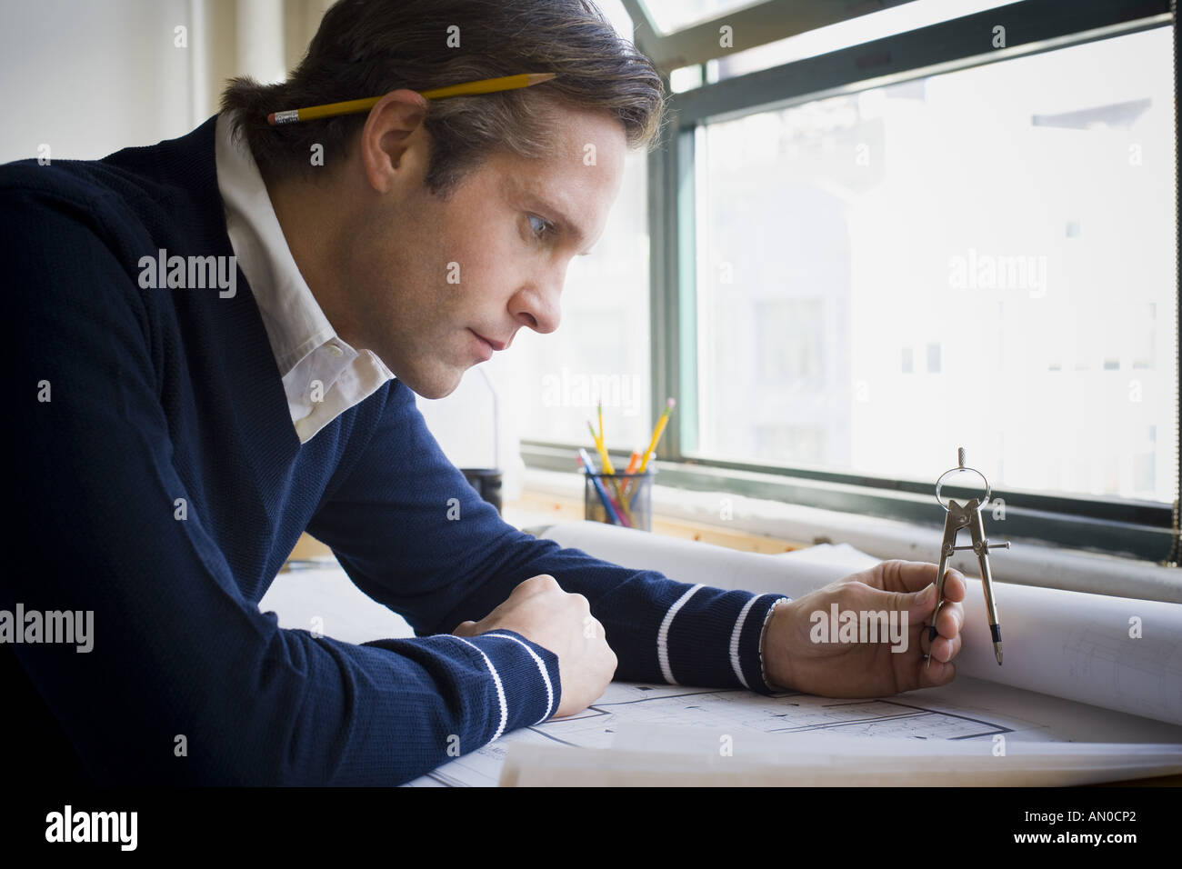 Profile of an architect looking over a blueprint Stock Photo
