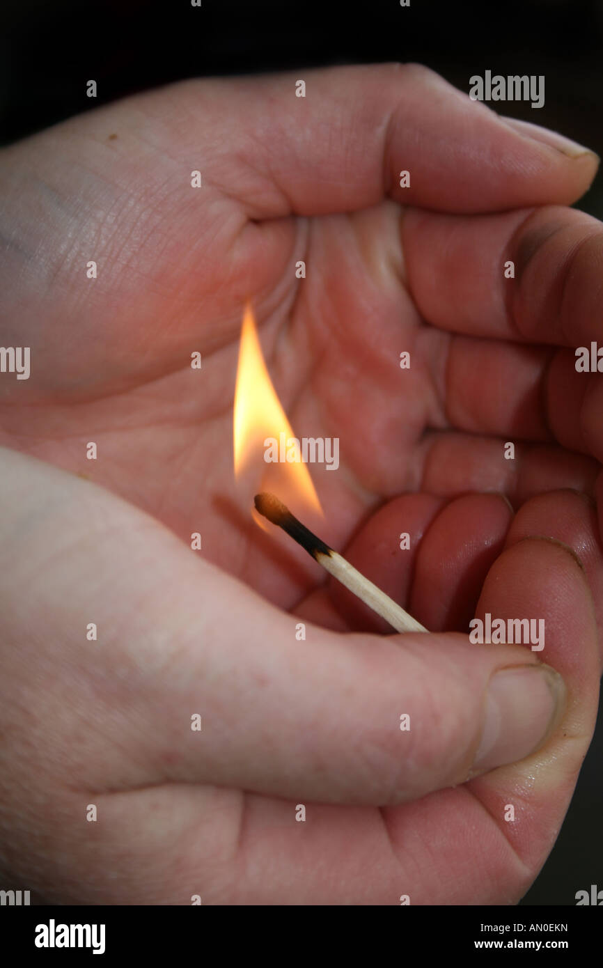 burning match held in hands Stock Photo