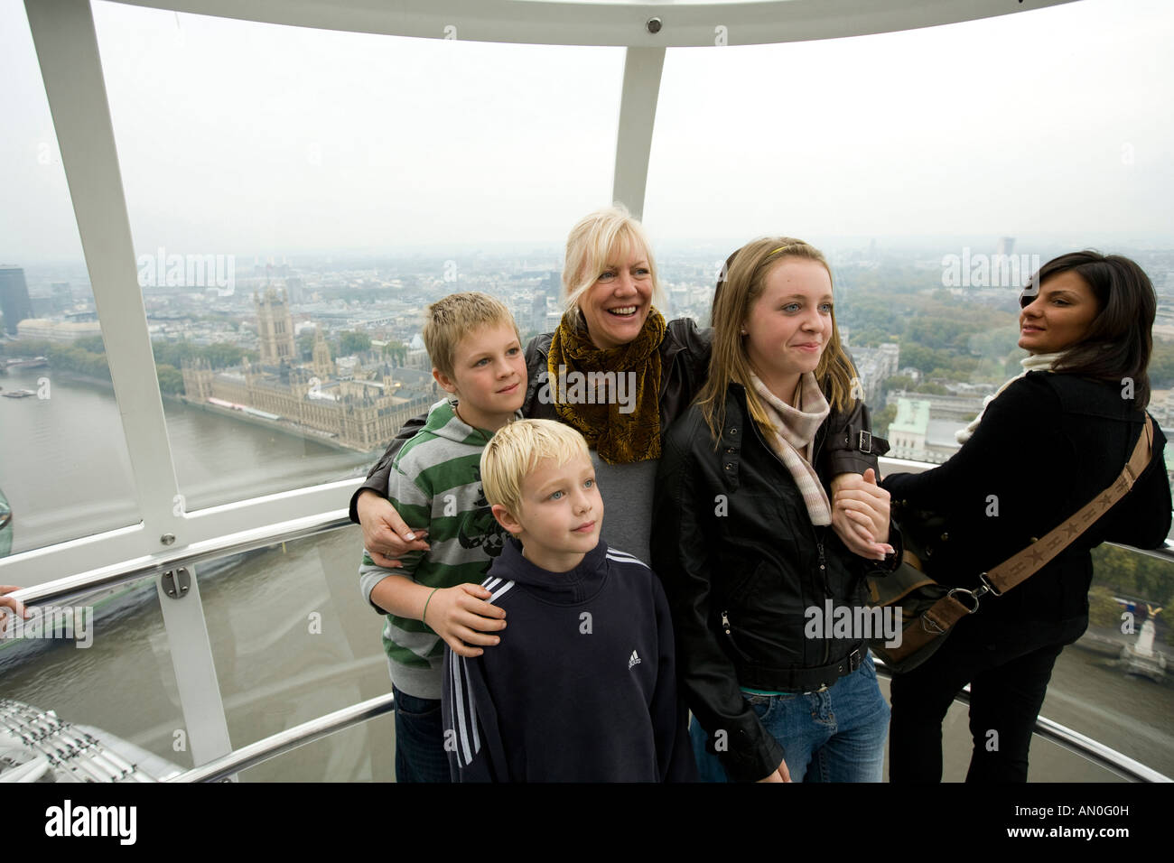 UK London South Bank London Eye passengers in capsule posing for souvenir photo above River Thames Stock Photo