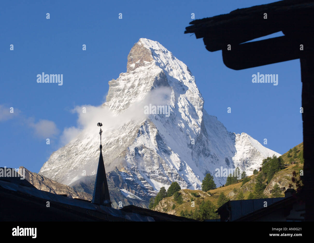 Peak of Matterhorn mountain with spire & weather clock of the English Church in Zermatt silhouetted in front Valais Switzerland Stock Photo