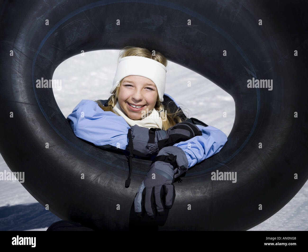 Portrait of a girl sitting on the snow with an inner tube Stock Photo ...