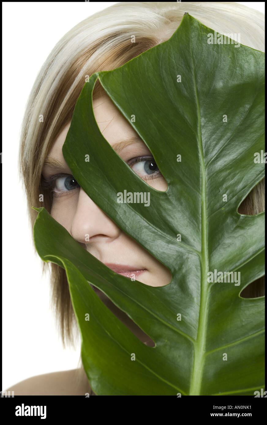 Portrait of a young woman holding a leaf in front of her face Stock ...