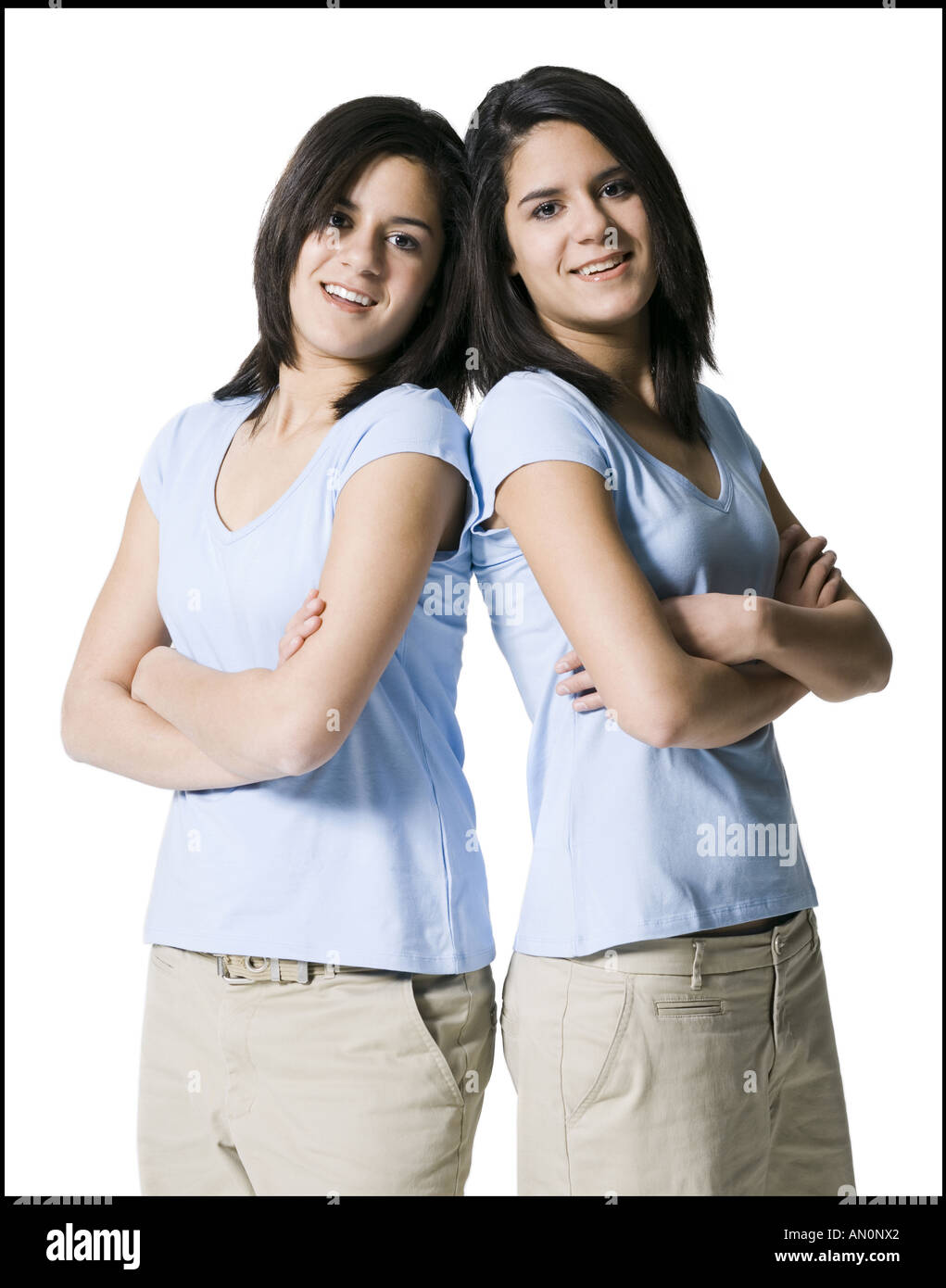 Portrait of two teenage girls standing back to back Stock Photo