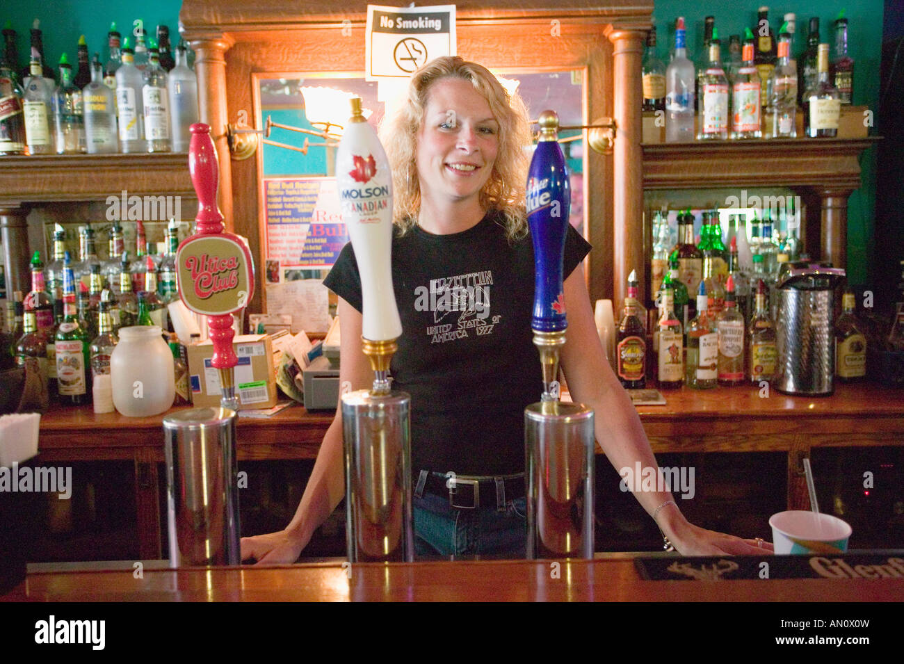 Female bartender Utica New York poses behind beer taps Stock Photo Alamy
