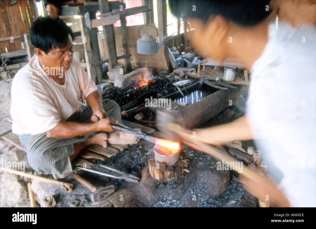 Ironmonger at work making metal pota and pans Inle Lake Myanmar Burma Stock Photo