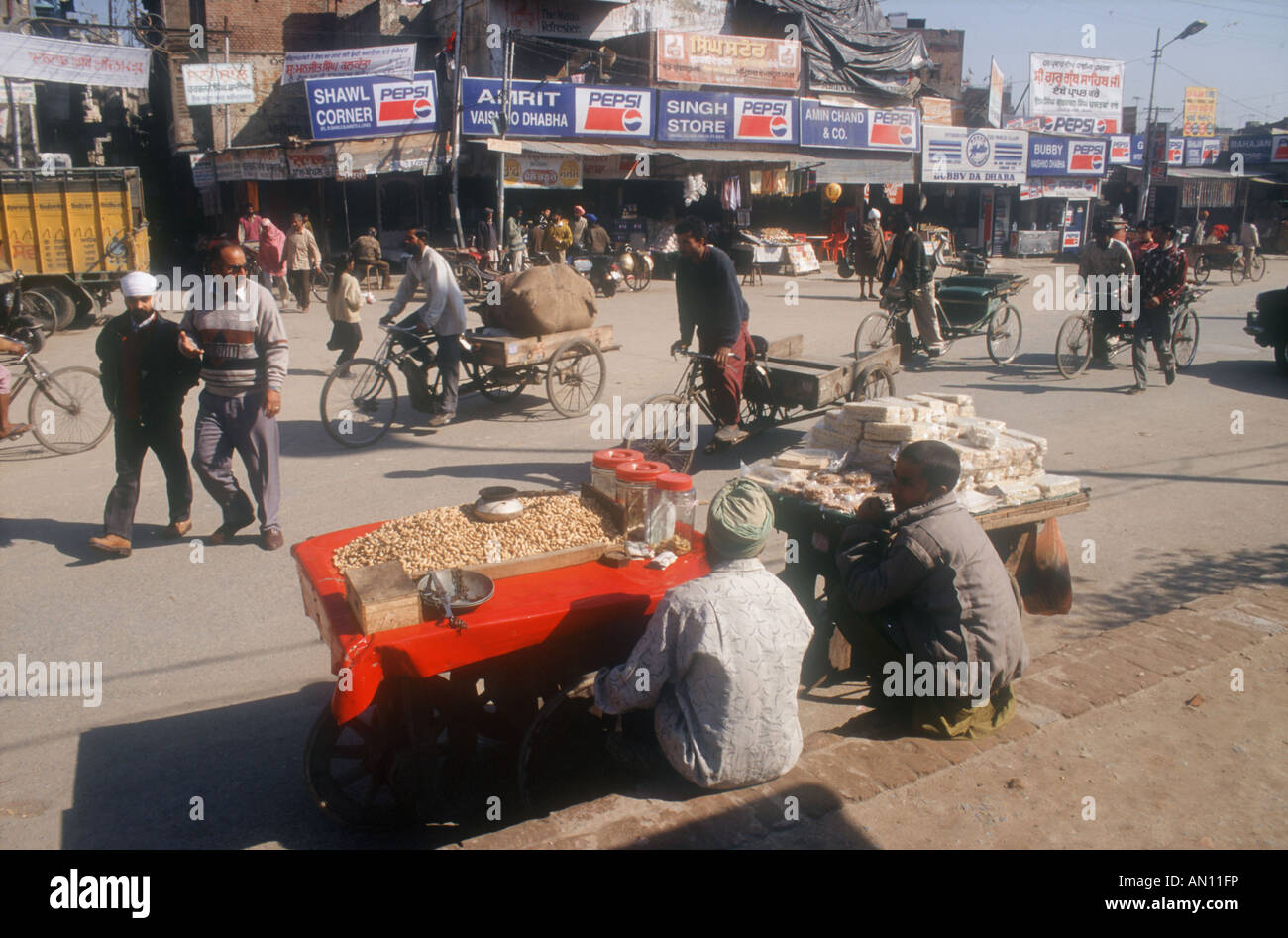 Street scene in Amritsar outside the golden temple with peanut stall ...