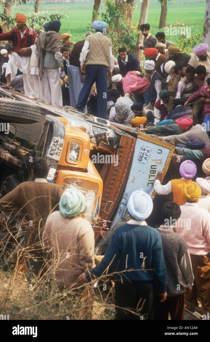 Road accident in the Punjab, India, near Patiala, with crowd of people surrounding overturned lorry. Stock Photo