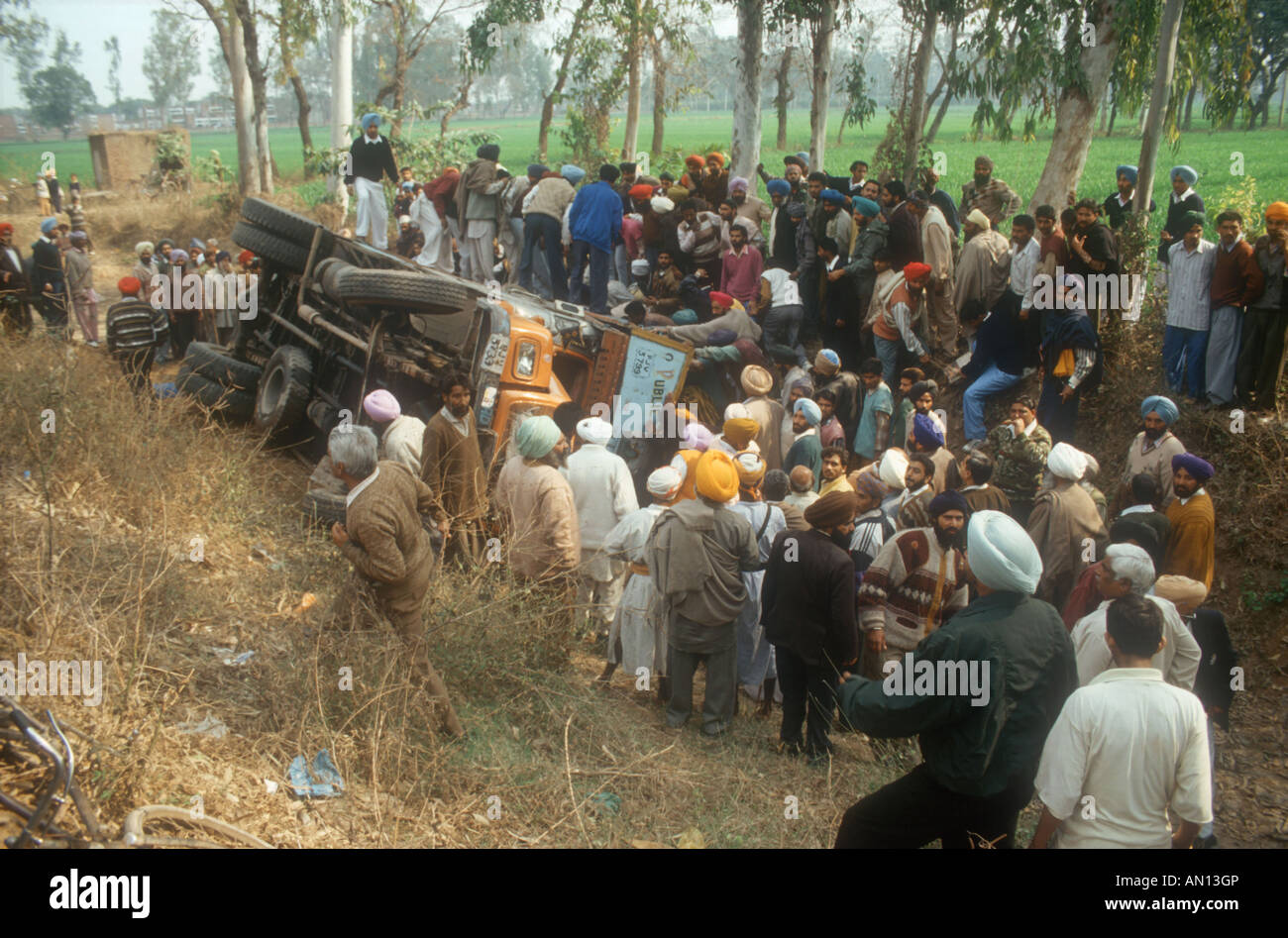 Road accident in the Punjab, India, near Patiala, with crowd of people surrounding overturned lorry. Stock Photo