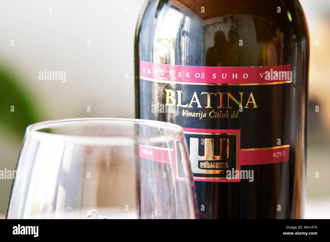 Wine glasses in the tasting room. Bottle of Blatina Vrhunsko Suho Vino red  wine. Detail of label with picture of a symbol. Vinarija Citluk winery in  Citluk near Mostar, part of Hercegovina