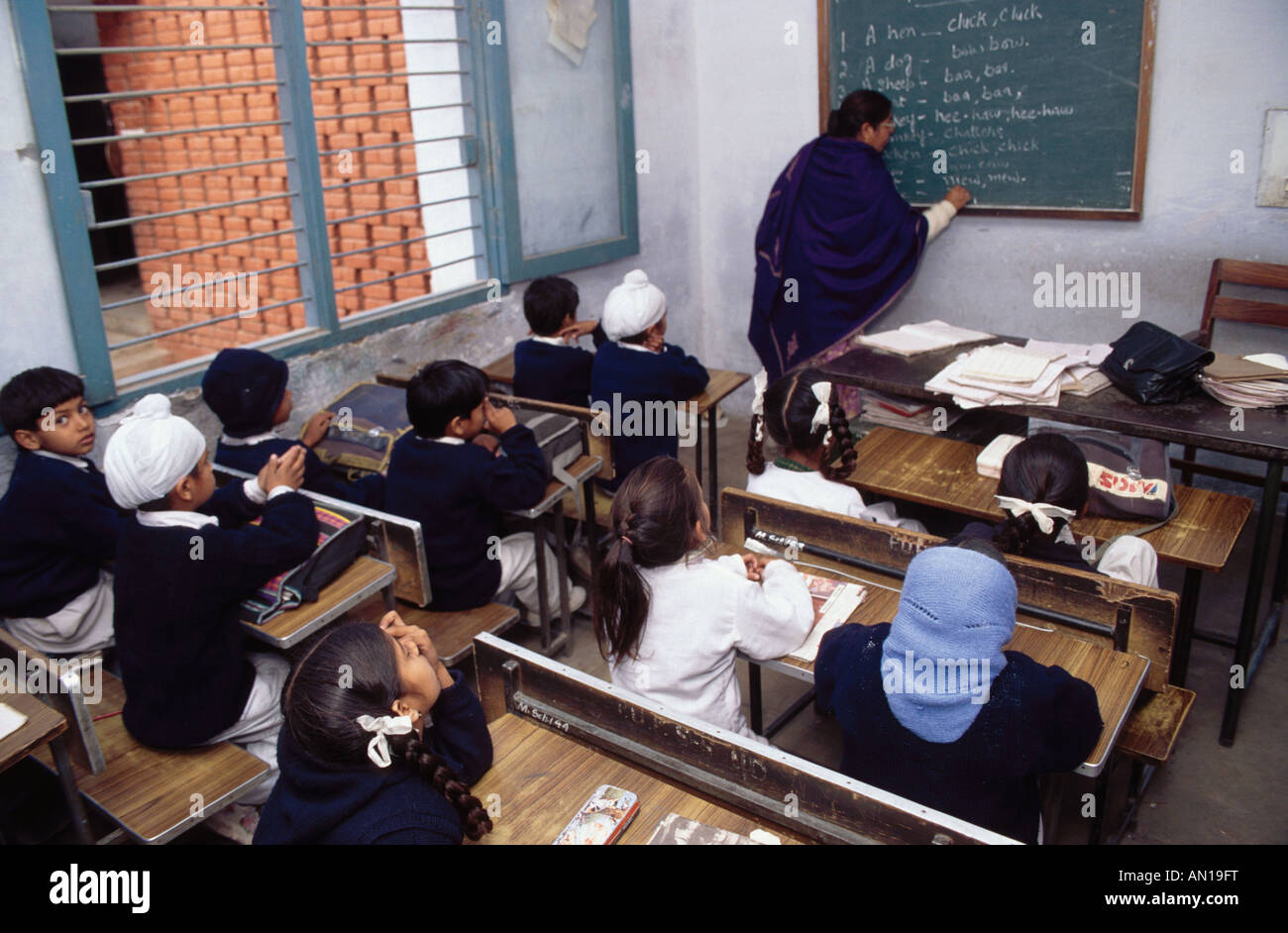 School girls and boys sitting at desks in senior secondary modern school, Punjabi University, Patiala, Punjab, India. Stock Photo