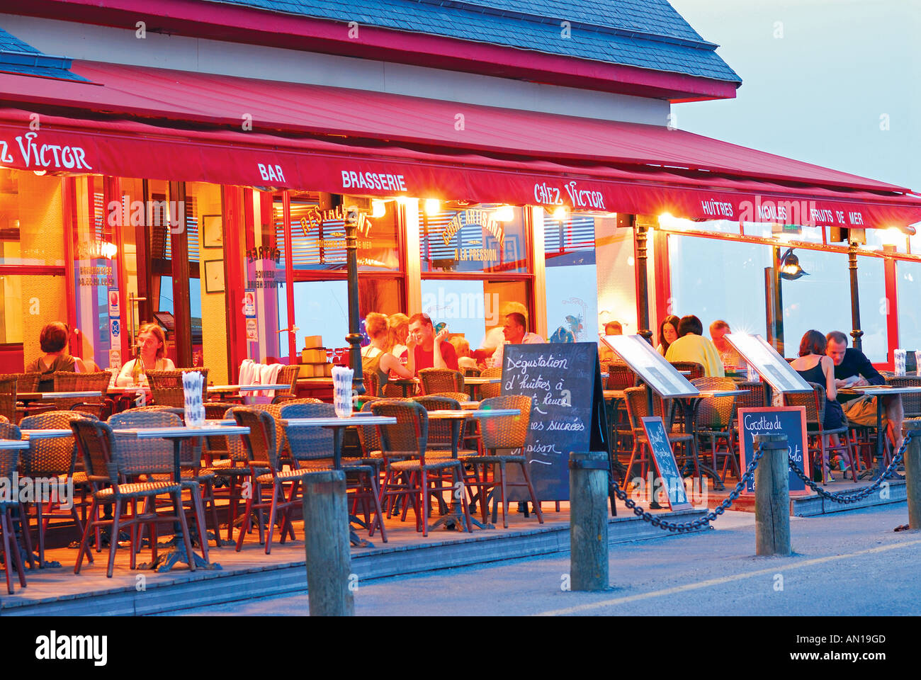 Restaurant at the harbour of oyster capital Cancale by night, Brittany, France Stock Photo