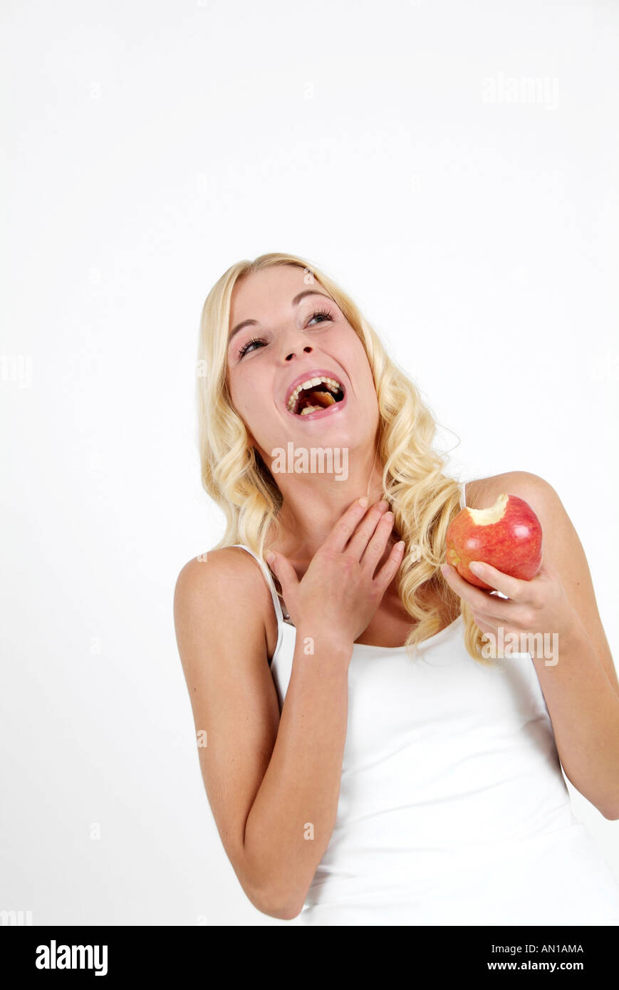 young woman enjoying a red delicious apple Stock Photo