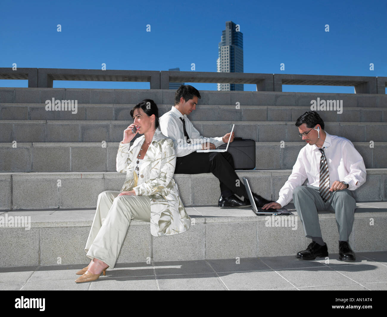Three people sitting on steps Stock Photo